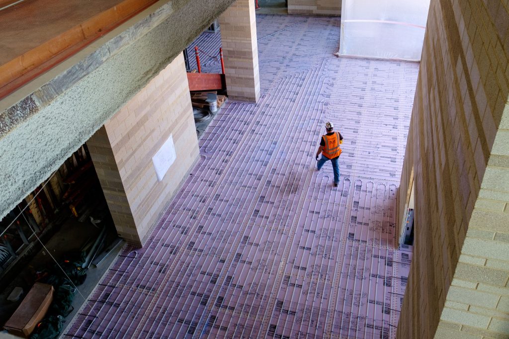 construction photography of a worker installing radiant flooring on a Arizona jobsite.